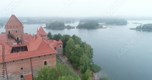 Trakai, Lithuania: medieval gothic Island castle, located in Galve lake and town in the background. Aerial above summer UAV top view, flat lay of the most beautiful Lithuanian landmark. photo