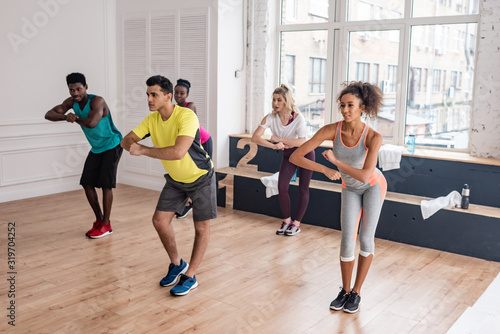 Multicultural zumba dancers training together in dance studio