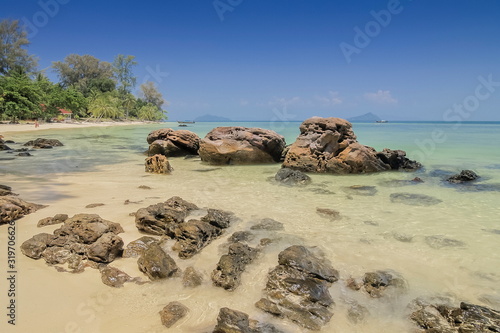 view seaside of many arch rocks floating in blue-green sea with blue sky background, Ko Bulon Le, Satun Province, southern of Thailand.