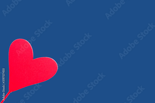 Red wooden heart on a blue background. For Valentine's Day celebration photo