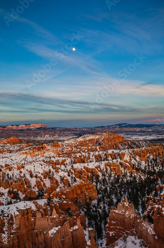 Night falling over Bryce Canyon National Park during winter covered with snow