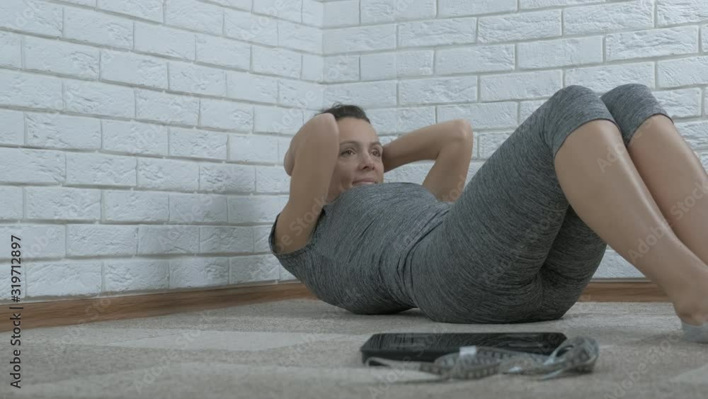 Exercise for lose weight. A woman is engaged in fitness, next to it are scales and a measuring tape. Body weight control concept. Exercise for lose weight. A woman is engaged in fitness, next to it are scales and a measuring tape. Body weight control concept.