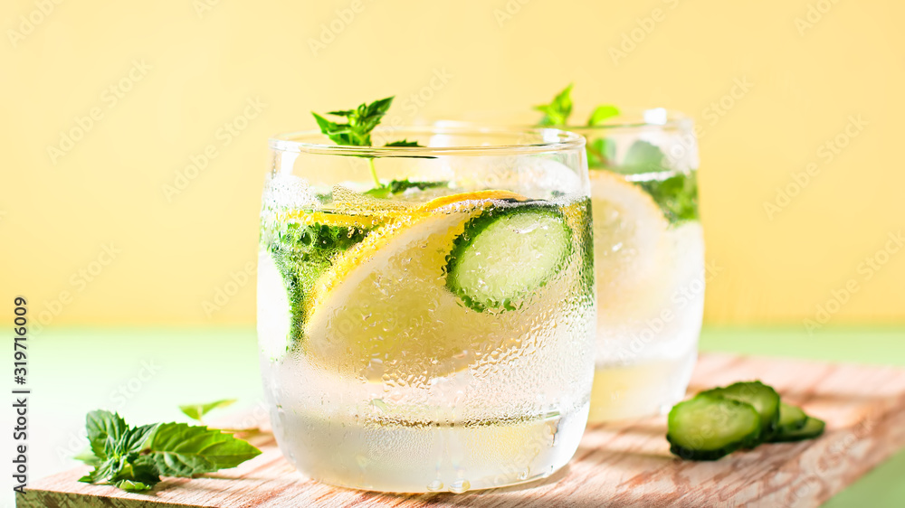 Healthy refreshing summer cocktail or mocktail without alcohol with lemon and cucumber. Summer detox drink on fresh green background, healthy living, top view Healthy refreshing summer cocktail or mocktail without alcohol with lemon and cucumber. Summer detox drink on fresh green background, healthy living, top view
