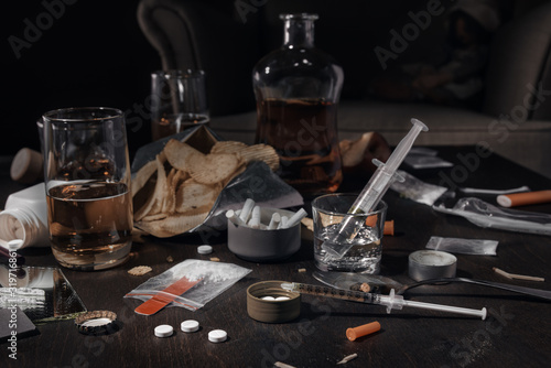 Various drugs  alcohol and cigarettes are on the wooden table. Substances that cause drug and alcohol dependence. Low key.