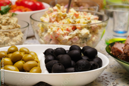 Black and green olives on a table with other products. Serving and serving option. Selective focus.