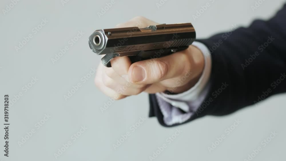 A business man in a jacket with a gun in his hand reloads the bolt and is ready to shoot A business man in a jacket with a gun in his hand reloads the bolt and is ready to shoot