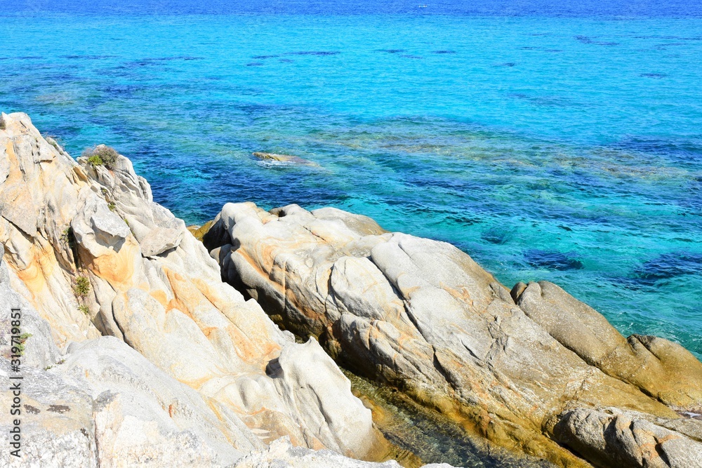 Seascape of rocky beach with azure sea water in sunny day. Amazing natural beach with white stones and turquoise water. crystal clear sea with sun reflection. Halkidiki Greece Blue Flag Beach