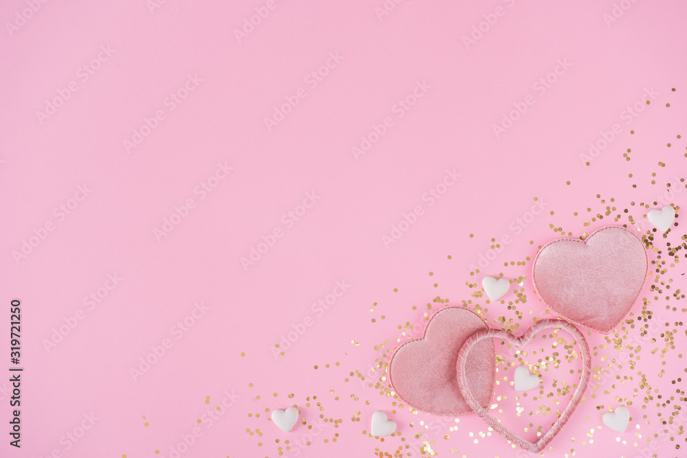 Creative layout with pink hearts and gold glitter on pink background. Nature flat lay. Minimal love concept.