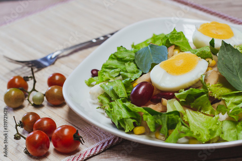 Vegetable salad, boiled eggs, tomatoes, tableware