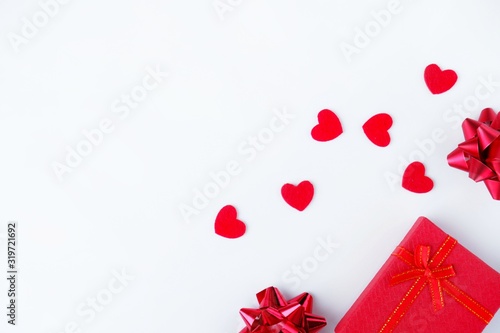 Gift box, bows and red hearts on a white background. The concept of Valentine's Day, love, romance, congratulations, holiday. Top view, flat lay, copy space for text.