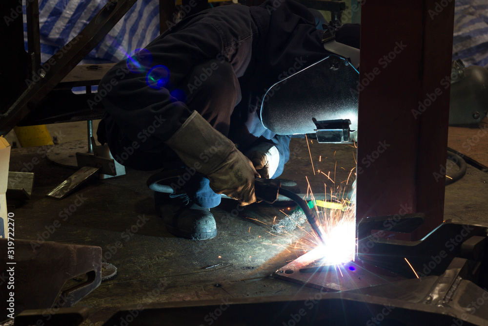 Metal workers use manual labor, Skilled welder, Factory workers making OT. Welder is welding the steel in the factory. Metal workers use manual labor, Skilled welder, Factory workers making OT. Welder is welding the steel in the factory.