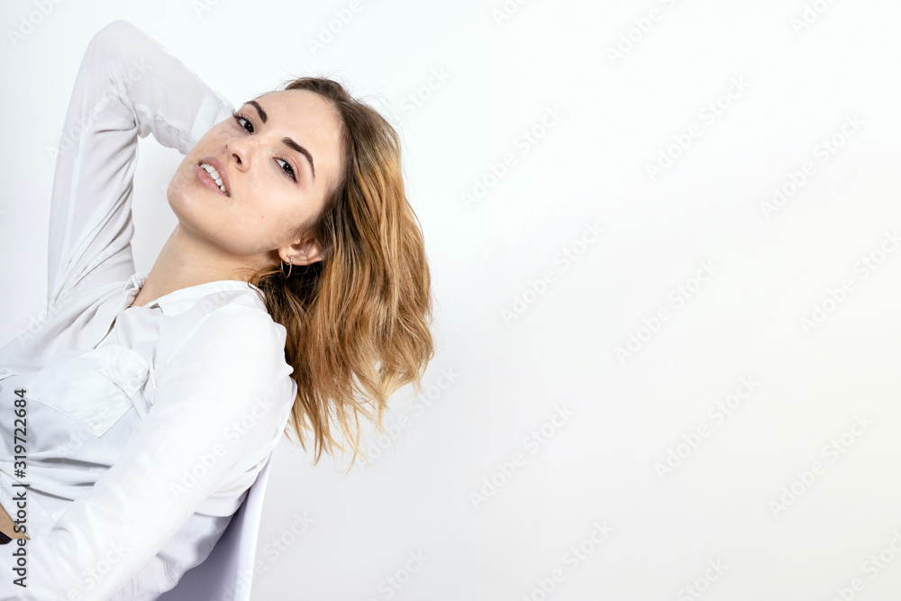 young pretty girl in a white shirt leaned back on a light background, copy space young pretty girl in a white shirt leaned back on a light background, copy space