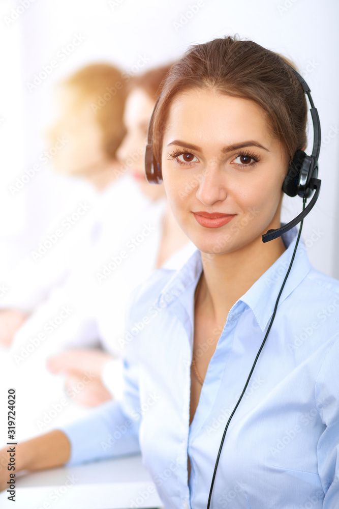 Call center. Focus on beautiful business woman using headset in sunny office Call center. Focus on beautiful business woman using headset in sunny office