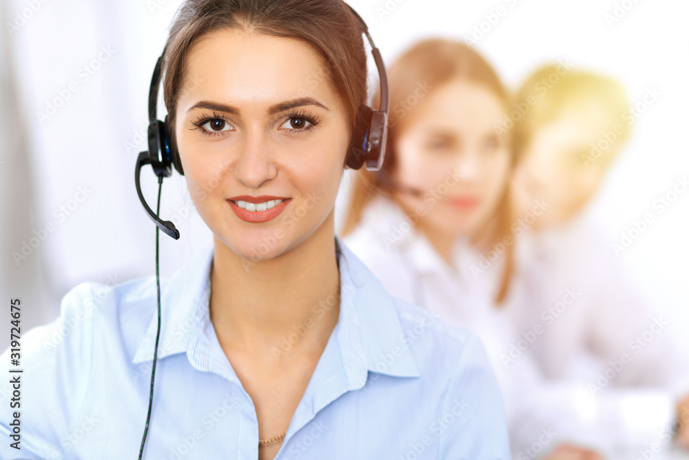Call center. Focus on beautiful business woman using headset in sunny office Call center. Focus on beautiful business woman using headset in sunny office