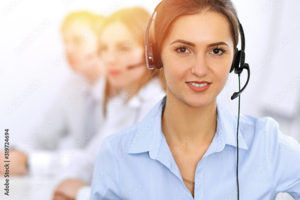Call center. Focus on beautiful business woman using headset in sunny office Call center. Focus on beautiful business woman using headset in sunny office