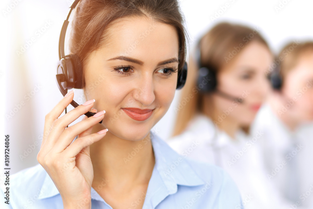 Call center. Focus on beautiful business woman using headset in sunny office Call center. Focus on beautiful business woman using headset in sunny office