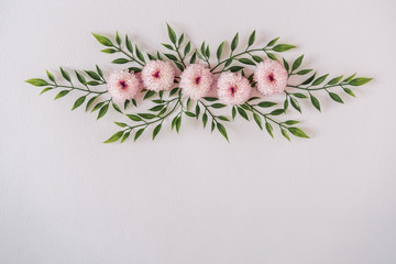 Pastel pink daisy flowers and leaves. Spring or summer frame background. Flat lay social mockup with copy space.
