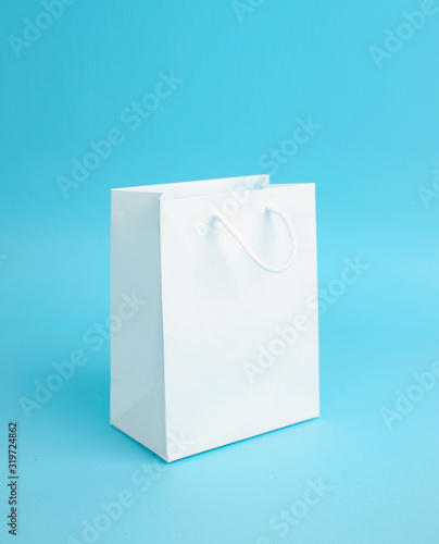 White empty paper bag on blue background.