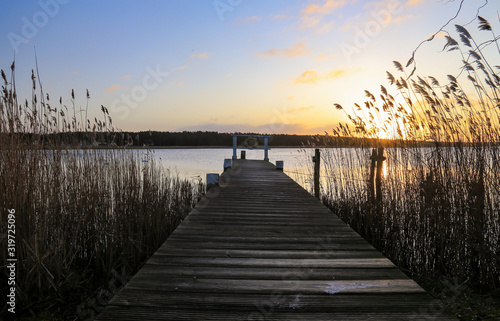 old wooden pier at small beautiful pond on sunset