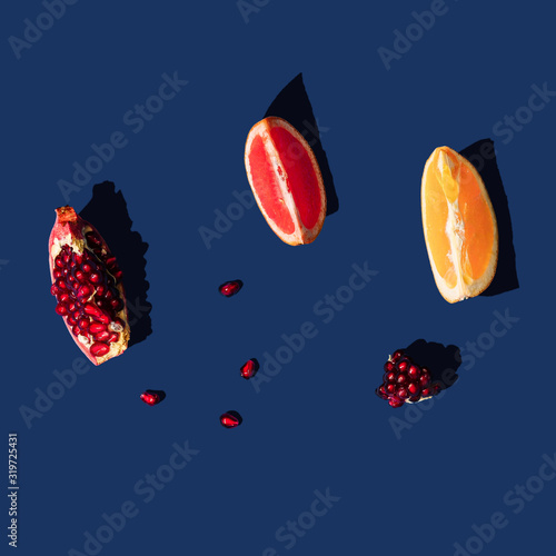Flat lay layout with summer citrus fruit on blue background. Minimal concept with sharp shadows. Trendy social mockup.