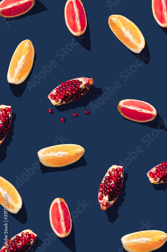 Flat lay pattern with summer citrus fruit on blue background. Minimal concept with sharp shadows. Trendy social mockup or wallpaper.