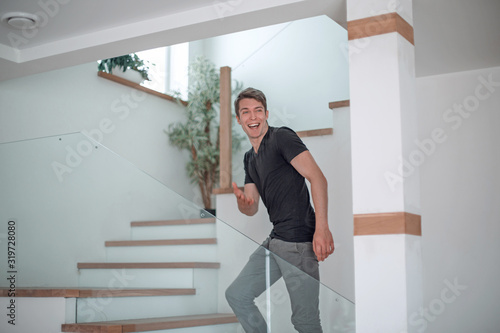 happy young man standing on the stairs in his new apartment.