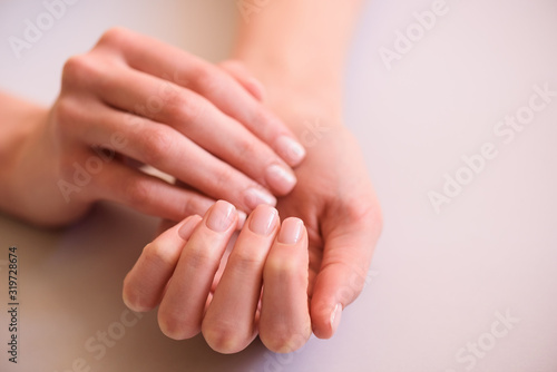 hands with neat manicure on a neutral background