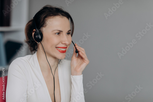 Call-centre lady employee happy of conversation with customer calling by headset