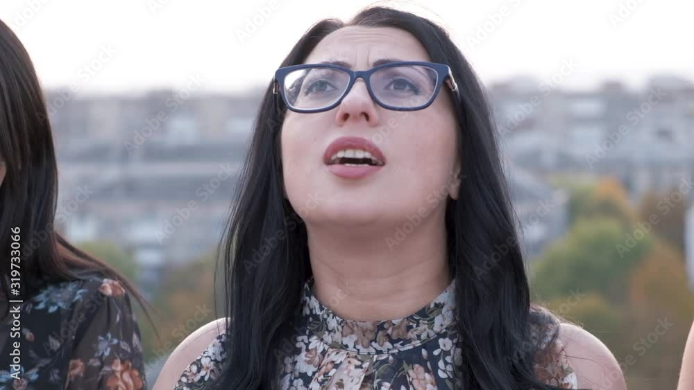 Happy black haired woman singing a song on warm summer day outdoors. Happy black haired woman singing a song on warm summer day outdoors.
