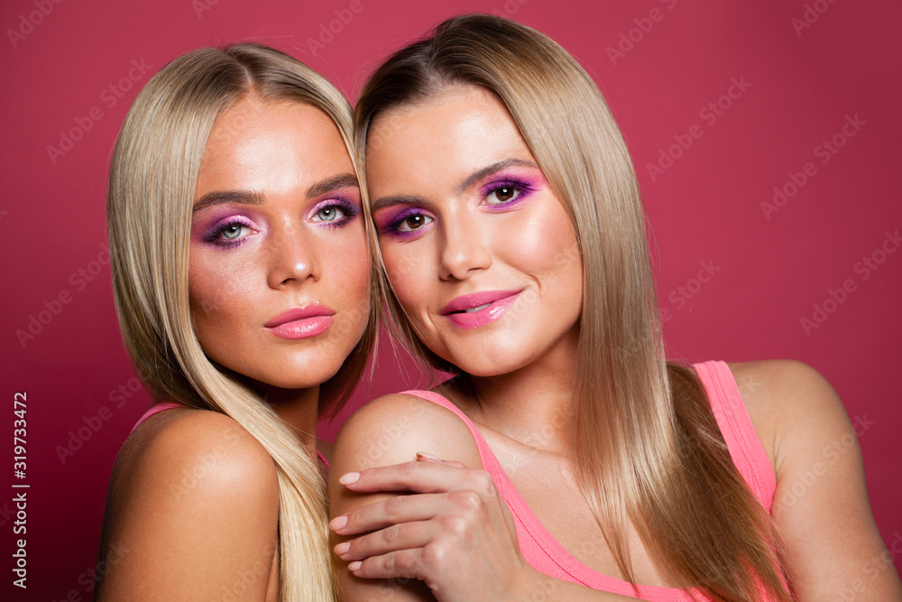 Pretty blonde women fashion models with long straight hair and makeup on pink background Pretty blonde women fashion models with long straight hair and makeup on pink background