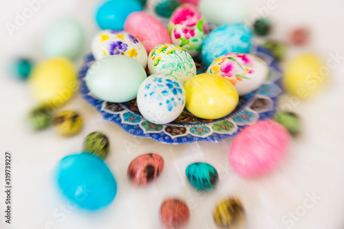 Colorful hand painted with watercolor easter eggs with painting of flowers on lace tablecloth