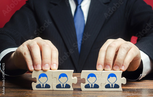 Businessman connects puzzles of workers employees into a single whole. Create effective specialists team for work on a new project. Restructuring, business optimization, HR staff management recruiting photo