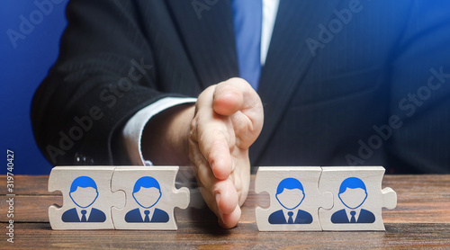 A man divides puzzle team of employees. Team split, structural fragmentation into small units. Improving company efficiency. Staff dismissal reduction. Distribution group members to parallel projects.