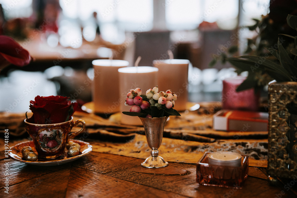 Beautiful, decorated table with flowers and red candles. Luxury Christmas evening or wedding party decoration. Beautiful, decorated table with flowers and red candles. Luxury Christmas evening or wedding party decoration.