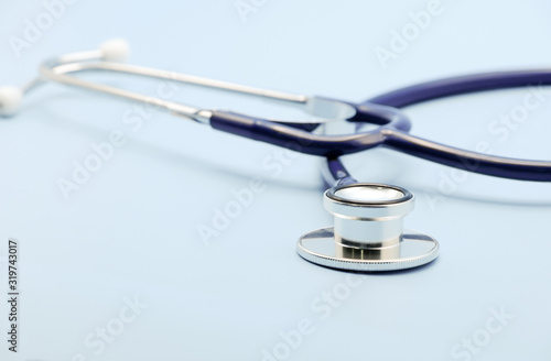 Close up on chest piece of stethoscope for doctor checkup on light blue background with copy space, healthcare and medical concept.