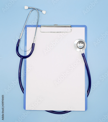 Принти на полотні Flat lay of stethoscope and writing pad paper clip board on light blue background with copy space, healthcare and medical concept, top view photo