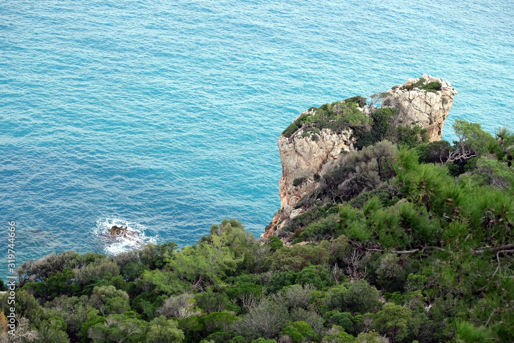 Landscape with high mountains covered with dense southern vegetation and wonderful clean turquoise water Mediterranean sea far below
