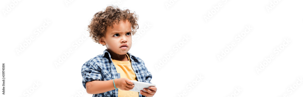 panoramic shot of little angry african american boy using smartphone, isolated on white panoramic shot of little angry african american boy using smartphone, isolated on white