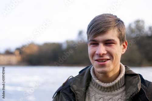 portrait of a young guy. man in outdoor nature on the background of a frozen lake