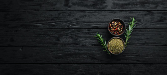 Peppers in a bowl on a black wooden background. Top view. Free space for your text.