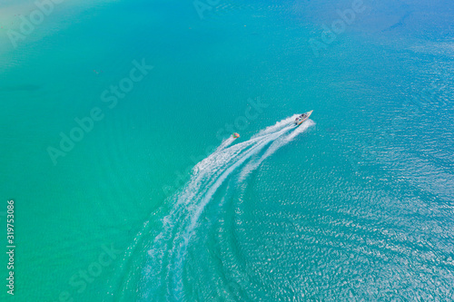 Aerial drone photo of extreme powerboat donut water-sports cruising in high speed in tropical turquoise bay. Thailand, Phuket, Kata beach