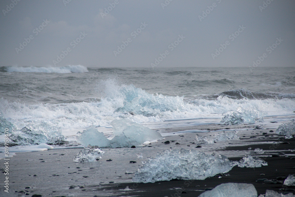 Fototapeta premium Ice chunks washed up on a black sand beach