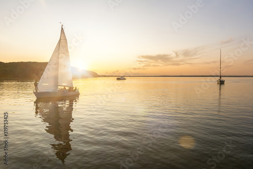 Sailing boats coming back into the harbor during beautiful sunset at the Baltic Sea