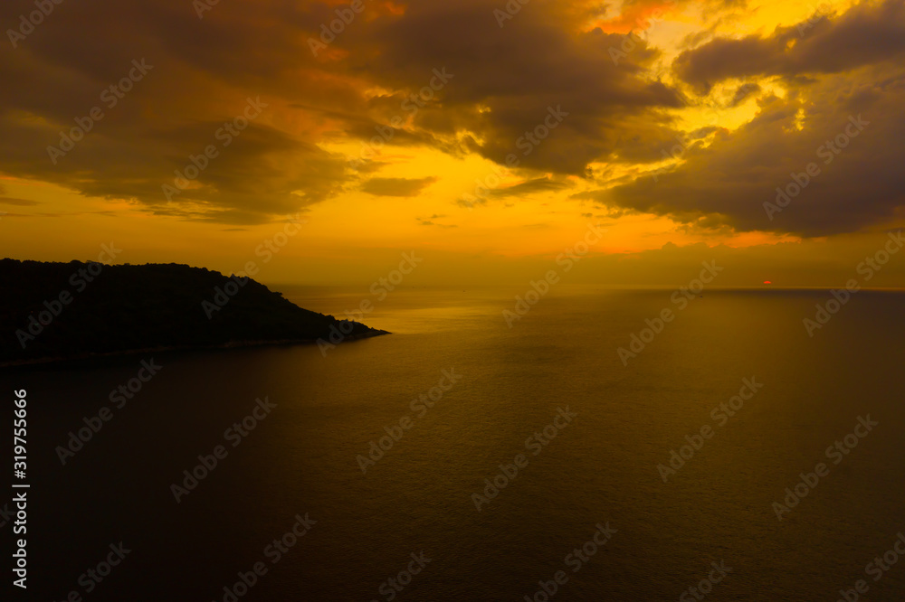 Aerial view of sunset over the sea , Phuket, Thialand. Sunset of sun setting over ocean. Tranquil idyllic scene of a golden sunset over the sea with reflection.