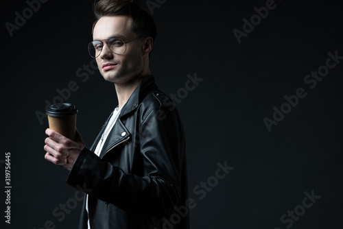 side view of stylish brutal man in biker jacket with coffee to go isolated on black © LIGHTFIELD STUDIOS