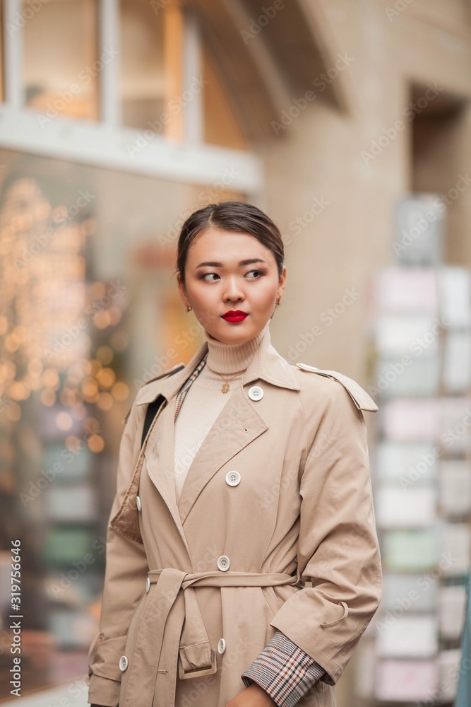 A beautiful young Asian woman walks in a European city.