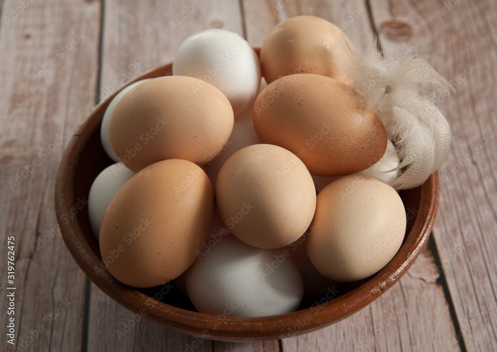 Easter composition. Fresh farm chicken eggs in a clay Cup close-up on a wooden background. Selective focus. Easter composition. Fresh farm chicken eggs in a clay Cup close-up on a wooden background. Selective focus.