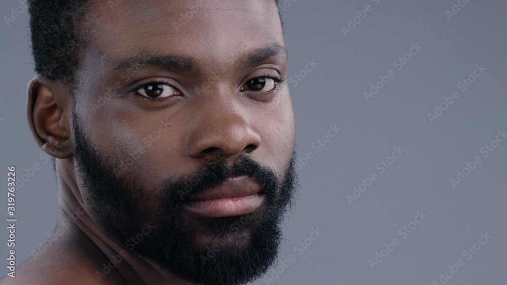 Fototapeta premium Close-up profile of handsome confident african american man with a beard looking forward isolated on grey background.