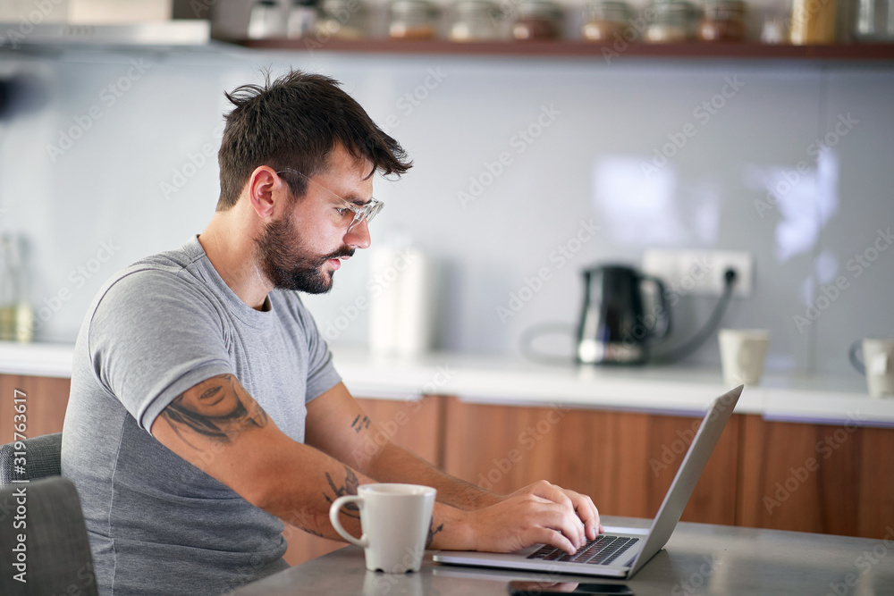  man  in the morning checking email on a laptop - obrazy, fototapety, plakaty 