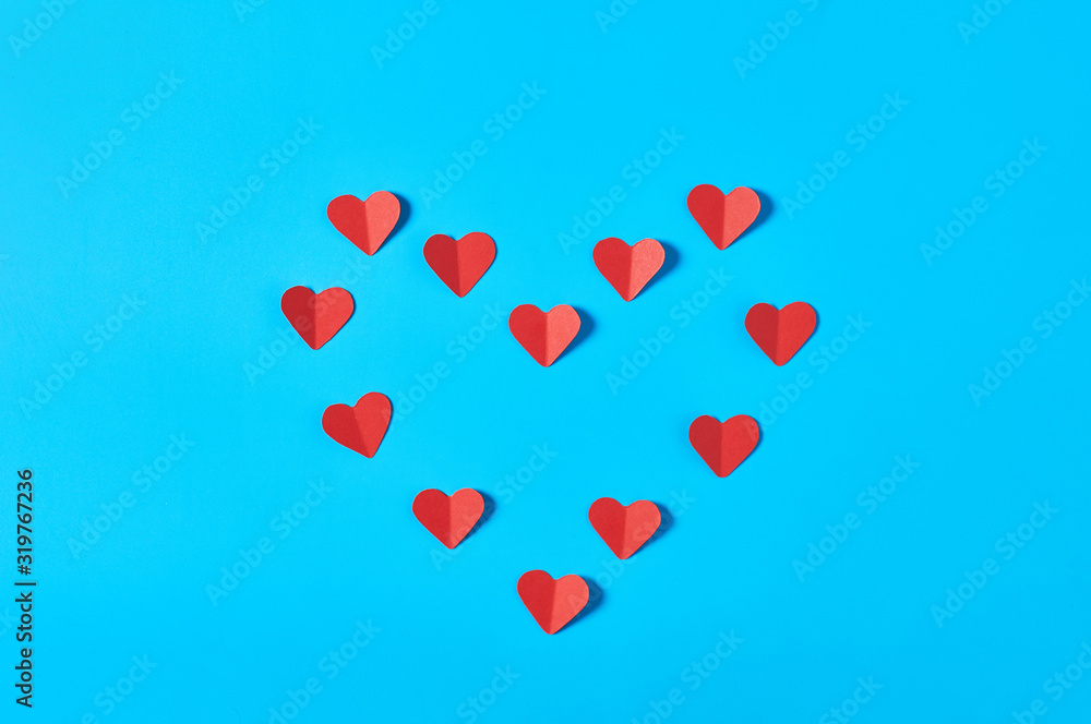 Red paper hearts lies on blue countertop. Concept of love or Valentines day. Top view. Close-up